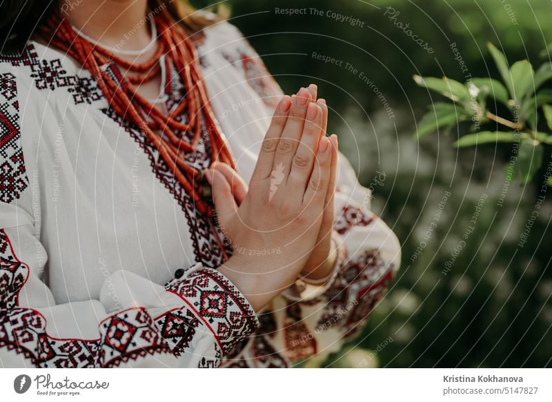 Pray for Ukraine, stand with. Ukrainian woman in traditional embroidery vyshyvanka dress holding hands in prayer gesture - anjali mudra. caucasian ukrainian