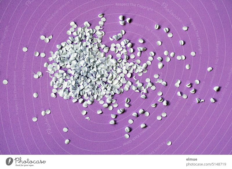 white punching waste of an office punch on purple background / office confetti Punching waste paper shavings Paper punch Confetti make yourself carnival