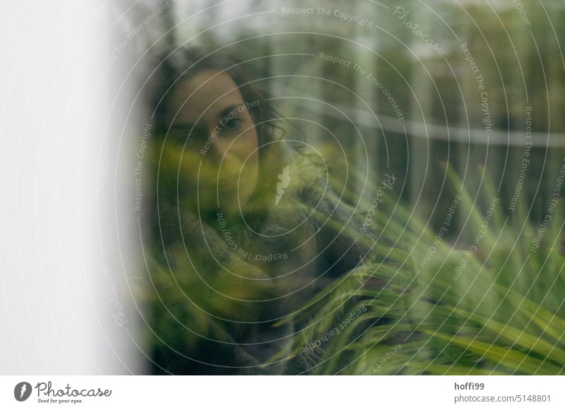 a woman wrapped in diffuse green looks through a pane into the camera portrait Adults Young woman Feminine Style Mysterious Movement melancholy Head Meditative