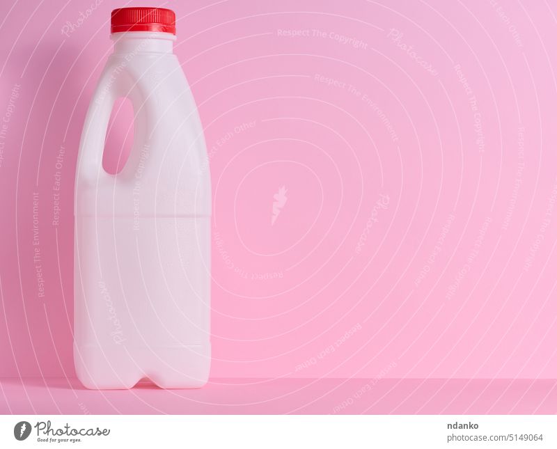 White plastic bottle for milk and dairy products on a pink background white drink liquid container jug gallon water cap can clean handle blank empty storage