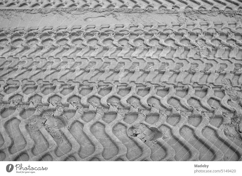 Rough tire tracks in the sand on the beach in Knokke-Heist on the North Sea near Bruges in West Flanders in Belgium, photographed in classic black and white