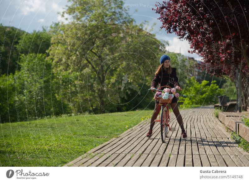 Girl walks with her red bicycle and flowers, along a wooden path. Woman bycicle Exterior shot Relaxation Colour photo Vacation & Travel To go for a walk Tourism