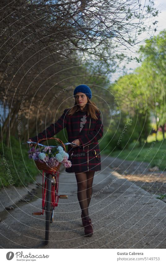 Girl and her thoughts, she rides her red bicycle with flowers. Woman Young woman Youth (Young adults) Colour photo Red bicycle Exterior shot Bicycle