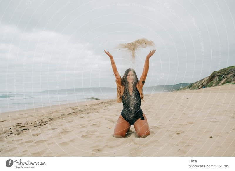 Woman in swimsuit throwing sand on beach Beach Sand Throw Joy vacation Swimsuit Vacation & Travel Ocean Young woman coast cloudy Human being Nature Exuberance