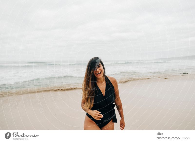 Laughing young woman with hair on face in swimsuit on beach Beach Ocean Woman laughing youthful Swimsuit Joy Good mood Positive vacation