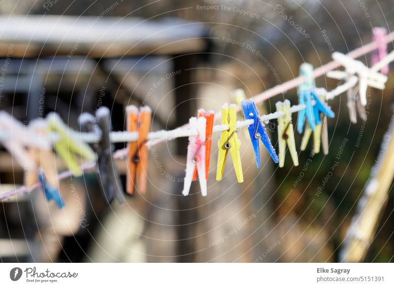 Colorful snow covered clothespins in winter Clothes peg Holder clothesline Laundry Hang Exterior shot Household Rope Clean Photos of everyday life Winter