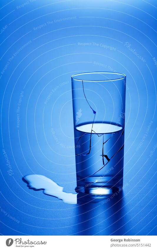 Depression.  Notice persons face in leaked water. glass of water water glass waterglass glasses of water waterglasses water glasses blue bluish half full