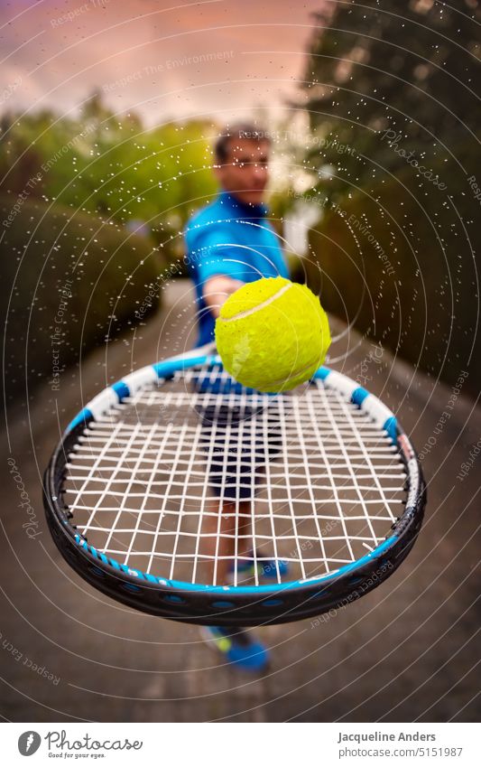 Man holding tennis racket with rotating and water splashing ball towards camera Tennis Tennis rack Ball Tennis ball Movement on the move Water squirting