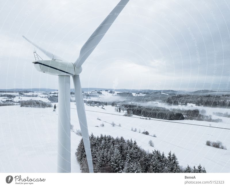 Bird's eye view of wind turbine in snowy winter landscape Antenna Carbon Clean Cleantech Climate Clouds cloudy Converter country Landscape Electric Electricity