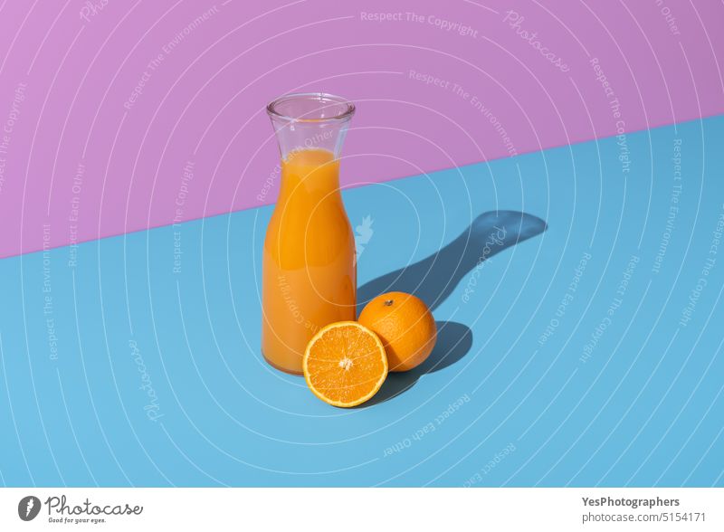 Orange juice carafe and orange fruits isolated on a vibrant background beverage blue bottle break breakfast bright citrus cold color colors copy space delicious