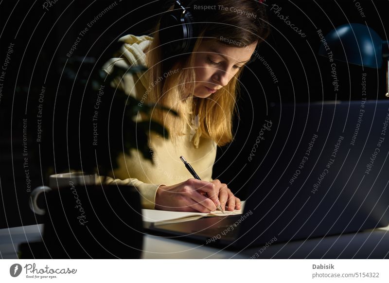 Woman at home workplace using laptop at night woman remote office online computer deadline study dark overwork desk business education class course designer