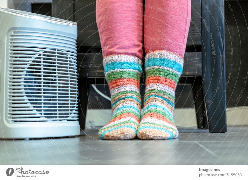 Heating season. Feet in socks. Heat room with fan heater electric heating at home. Warm period Holiday season feet Room Electric heating more adult Equipment