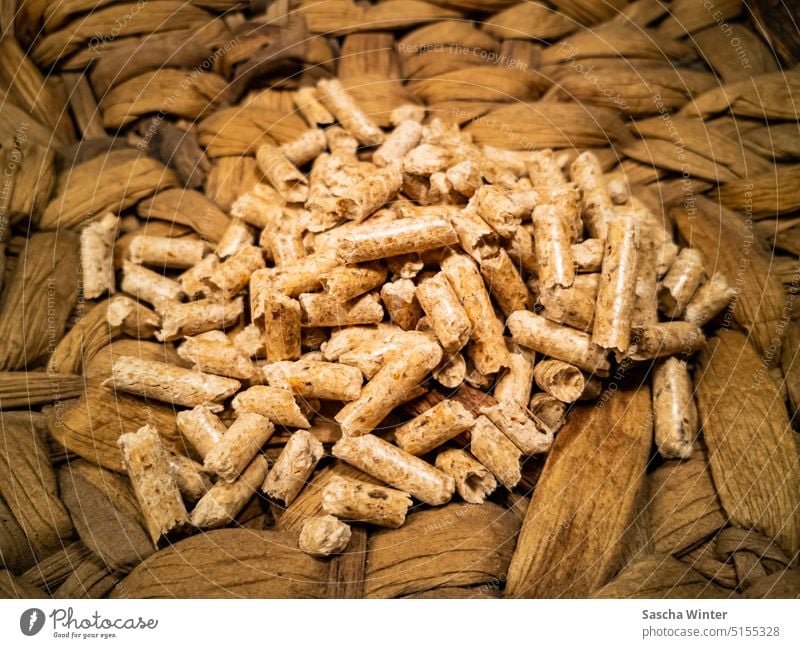 Close up with focus on brown shiny wood pellets on woven water hyacinth Wood pellets Sustainability Renewable raw materials Climate Neutral Climate neutrality