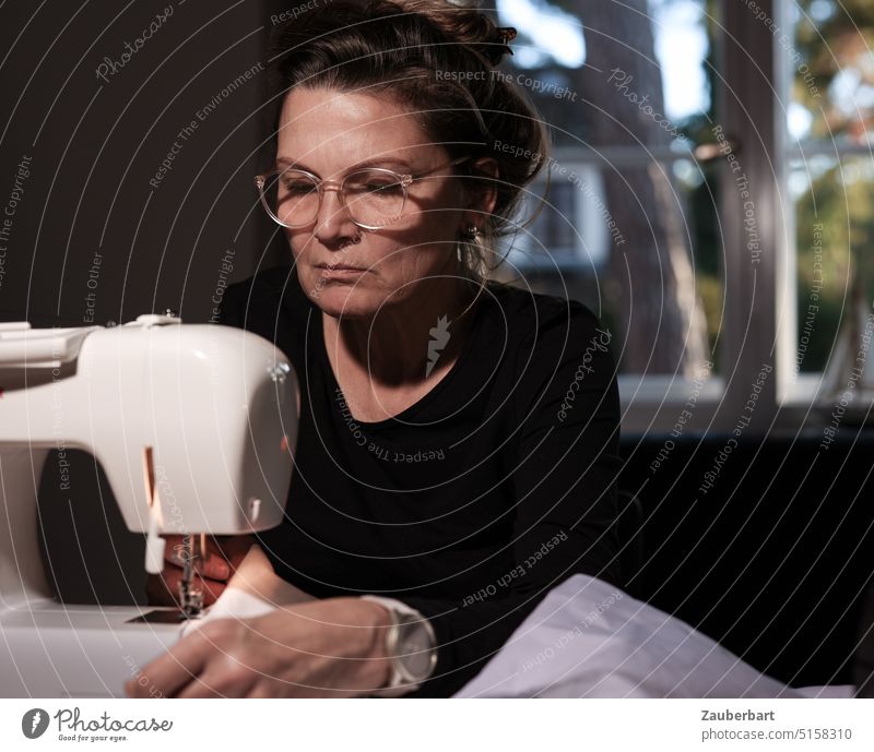 The seamstress I - woman sitting at the sewing machine with concentrated look Woman Sewing machine hobby devotion Concentrate Handcrafts Craft (trade) Needle