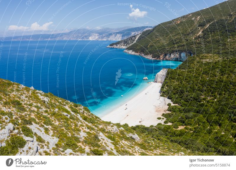 Stunning view of Fteri beach with white sailboat in hidden bay, Kefalonia, Greece. Surrounded by mediterranean vegetation. trekking path. Amazing seascape