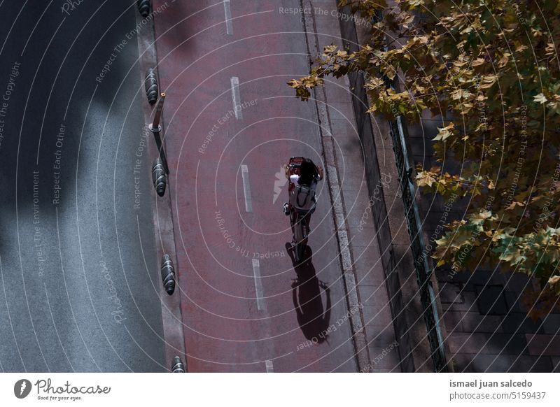 cyclist on the street, bicycle mode of transportation in the city biker cycling biking exercise activity lifestyle ride speed fast shadow silhouette road urban
