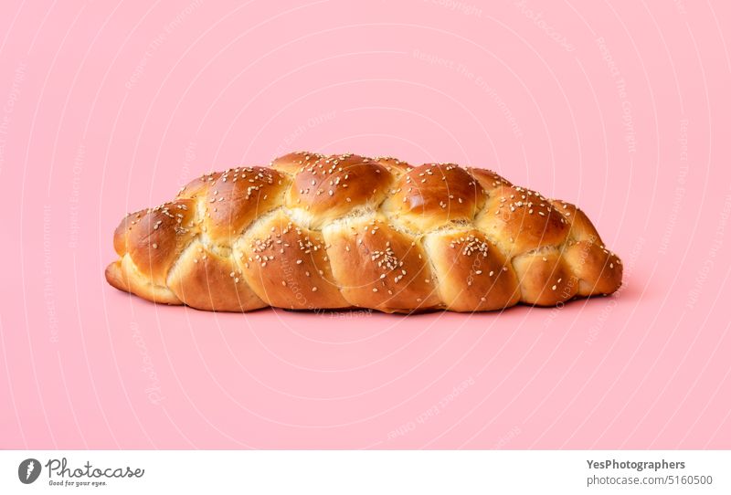 Braided bread isolated on a pink background. Homemade challah bread Sabbath above baked bakery braided breakfast bright celebration close-up color copy-space