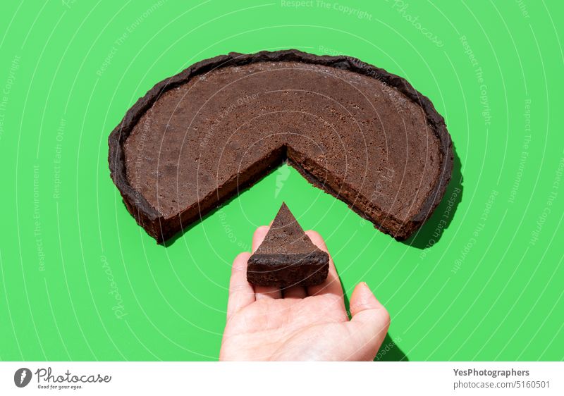 Chocolate tart isolated on a green background. Taking a slice of cake baked black bright brown business calories chart chocolate cocoa color concept copy space