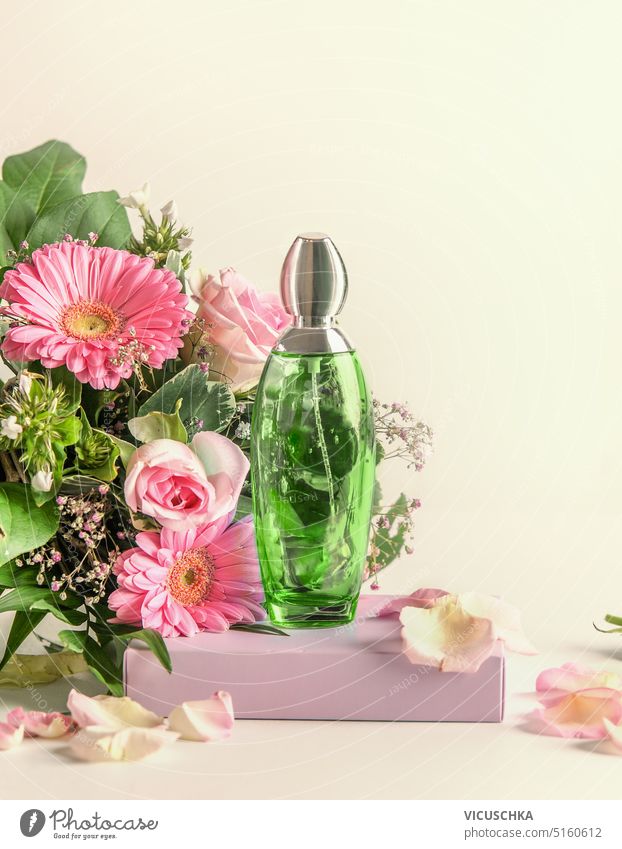 Green perfume bottle on podium with flowers bunch, front view. Natural floral scent green natural elegant fragrance branding template product glass cosmetic