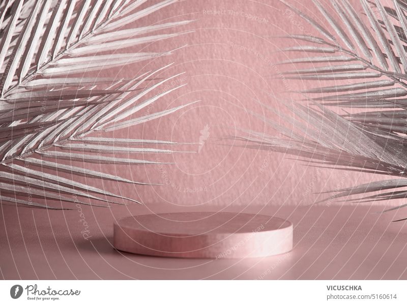Empty podium with sibver palm leaves and shadow on pastel pink background. Scene stage showcase mock up. Advertising template silver empty scene stage