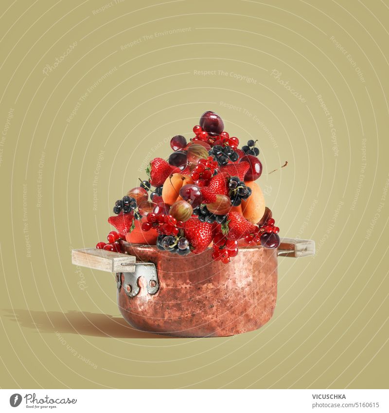Copper cooking pot full with summer fruits and berries for jam making , front view copper strawberry sweet delicious food healthy