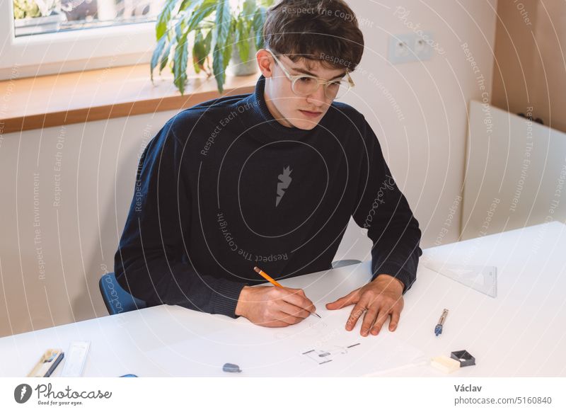 Brown-haired architect creates new product designs for a new futuristic world. Working with your own creativity. Compass, pencil, ruler and paper. Creative home office