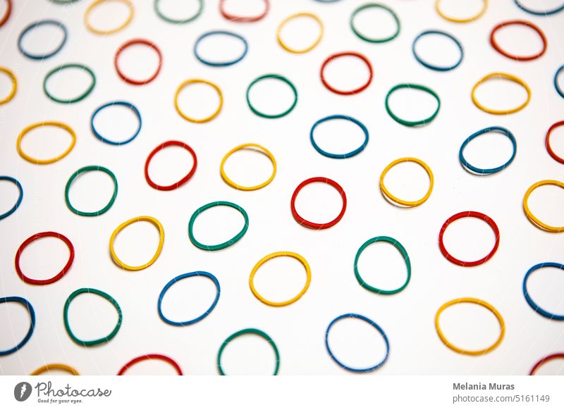 Colourful rubber band background. Office supply, elastic band. Many colour circles on white background, abstract pattern. arrange bands blue business circular