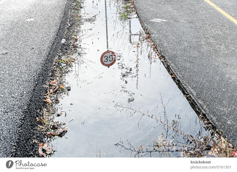 30 km/h speed limit Puddle Street Reflection Exterior shot Water Asphalt reflection puddle mirroring Speed limit tempolimit Traffic infrastructure