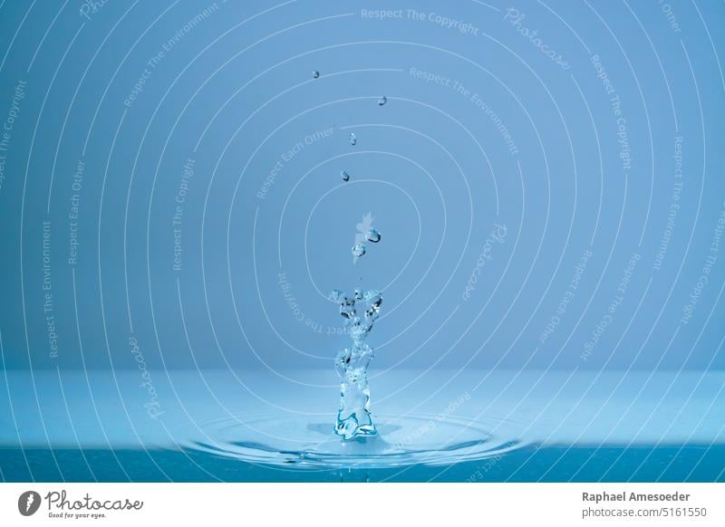 Water fountain and splashing drops above water surface abstract aqua aquamarine aquatic background bead blue bright bubble burble clean clear close up drip