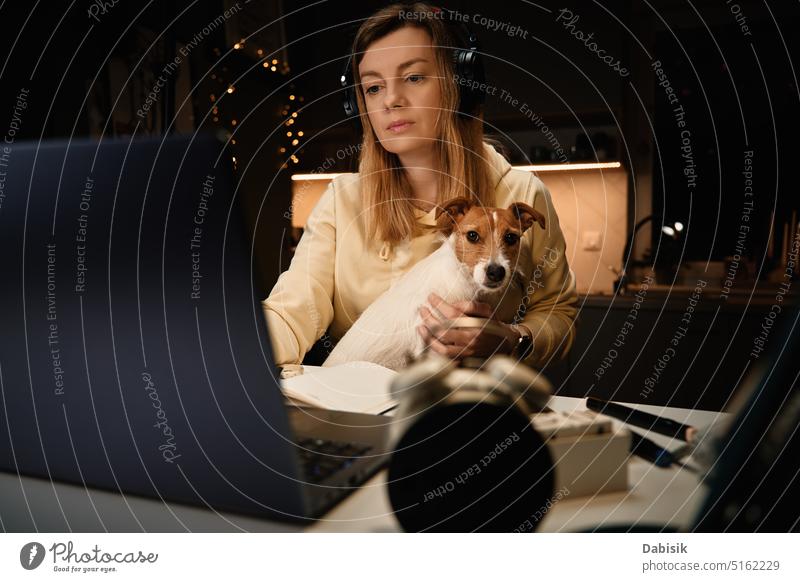 Woman and dog using laptop at night woman working pet distance home affection online office comfortable friend animal best breed browse candid canine companion