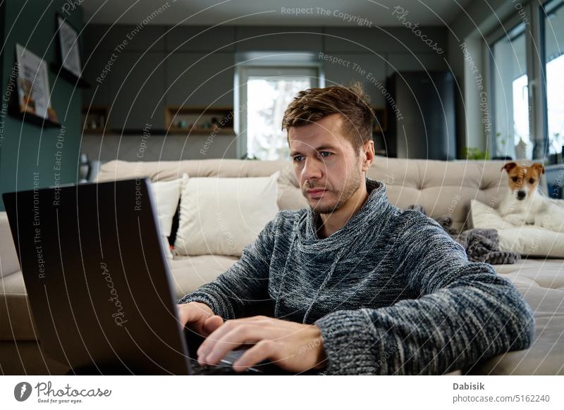 Man using laptop at living room work home man remote lifestyle online freelancer work from home dog pet busy business workplace interior portrait internet
