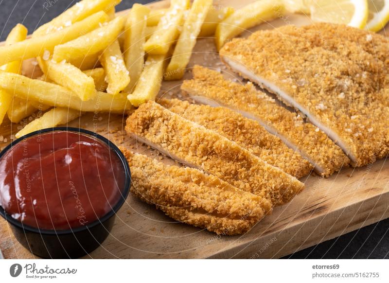 Wiener schnitzel with fried potatoes on black background chicken chips delicious dinner escalope fillet food french fries german lemon meat pork protein recipe