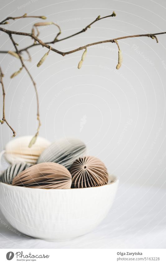 Easter egg-shaped decorations and branches. easter paper hang bowl table tablescape pastel ornaments scandinavian style lifestyle twig DIY craft idea beautiful