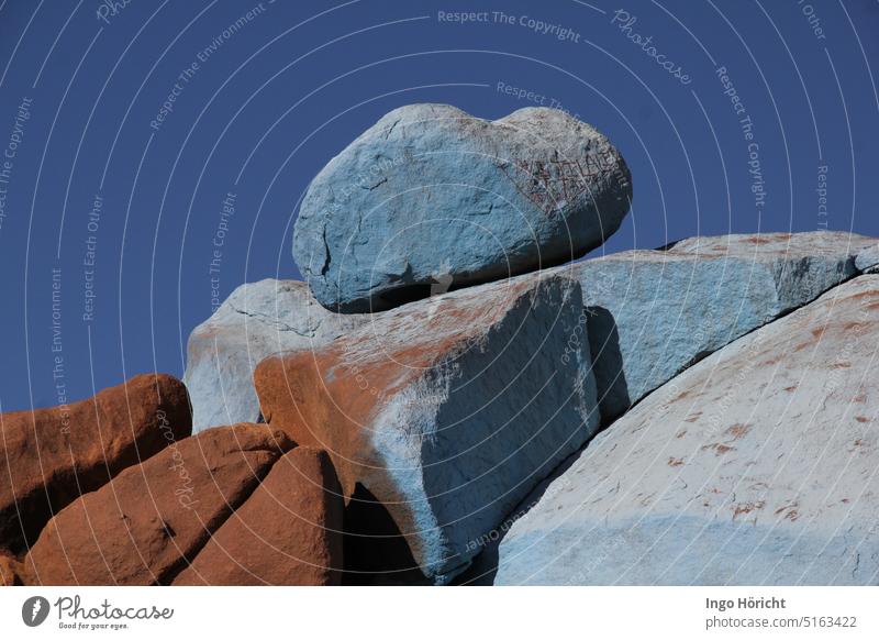 Rounded rocks painted by an artist light blue. At the top is a heavy rounded boulder. Behind it blue sky. Rock Art Nature Sky Sky blue Blue Colour photo