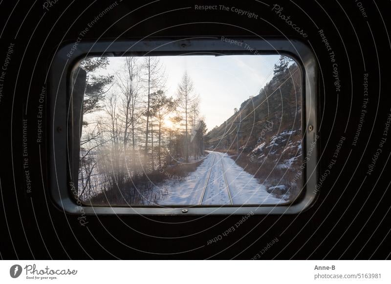 View from the very last window of the Baikal Railway on a snowy landscape with footprints in the snow between the tracks, the conductor heated the train with wood and coals. He was very warm.