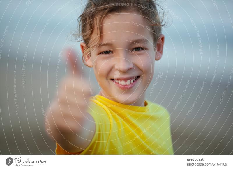 Outdoor portrait of a happy boy with thumbs-up thumbs up teenage child approve kid excited positive thinking agree joy cheerful advice choice joyful finger