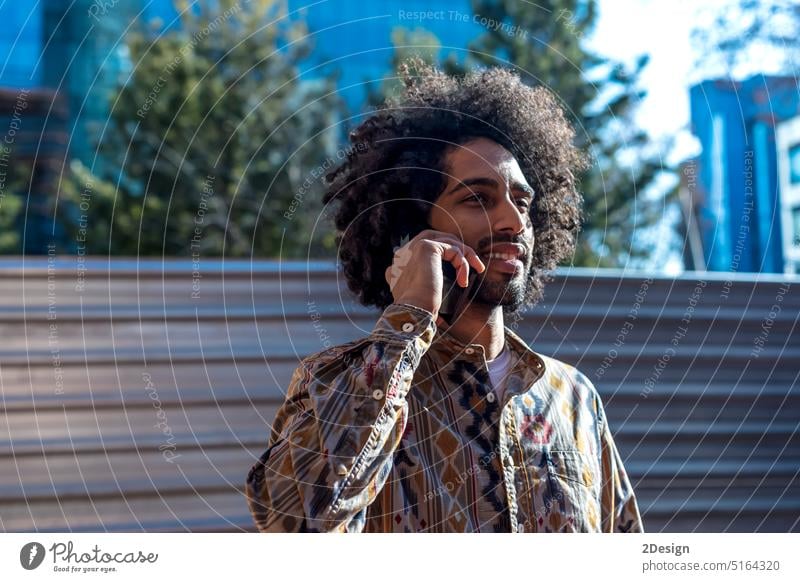 Young afro man using cellphone outdoor brick mobile mobile phone holding portrait male guy standing wall leaning african american adult beard black wireless