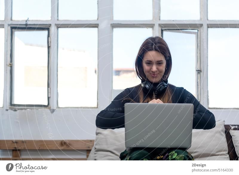 Beautiful business woman sitting holding a laptop at home indoor person computer female young lifestyle beautiful online portrait using technology businesswoman