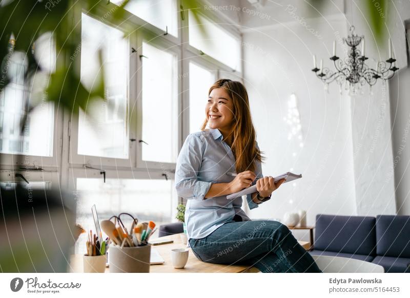 Portrait of a smiling creative woman sitting in a modern loft space real people millennials student indoors window natural girl adult one attractive successful