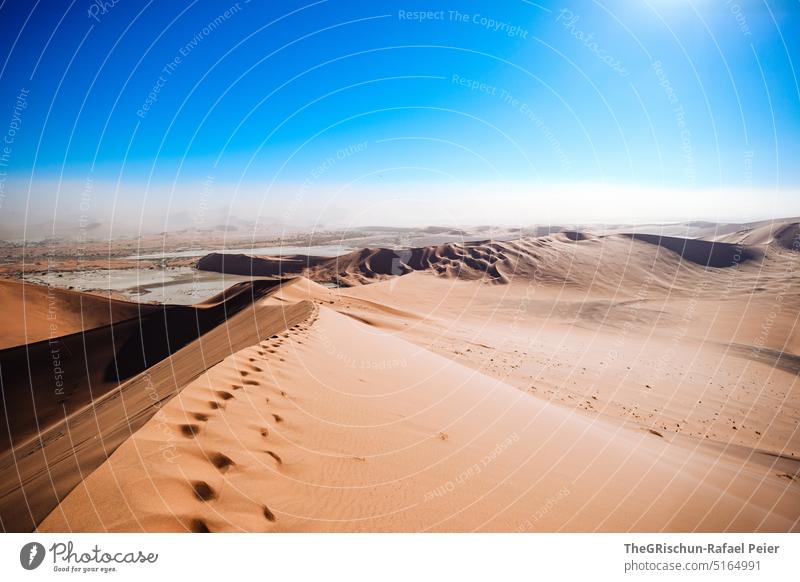 Sand dune with tracks against blue sky and sandstorm Namibia Desert Sossusvlei duene Dry Hot Africa Landscape Nature Far-off places Warmth Namib desert