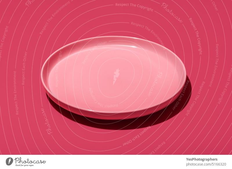 Pink plate isolated on a vibrant magenta background above backdrop blank breakfast bright ceramics clean close-up color concept copy space cuisine cut out
