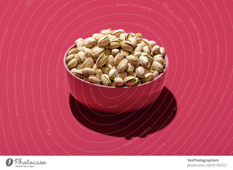 Pistachio in a pink bowl, minimalist on a magenta background above bright brown color cracked cuisine cut out delicious diet dinner dish dried dry eating food