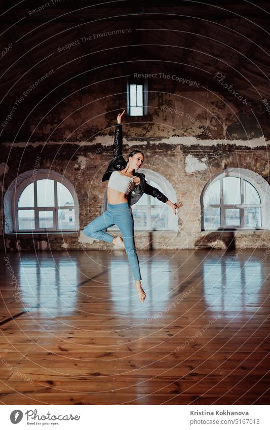 Woman jumping in casual style doing ballet in old studio. Attractive ballerina adult aerobics art artist attractive background balerina beautiful beauty body