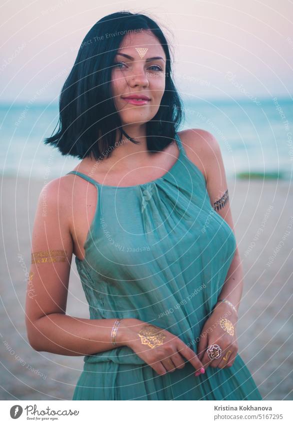 Portrait of stylish woman on beach. flash tattoos on hands.Bohemian style, gypsy model beauty fashion girl hair summer portrait jewelry female beautiful young