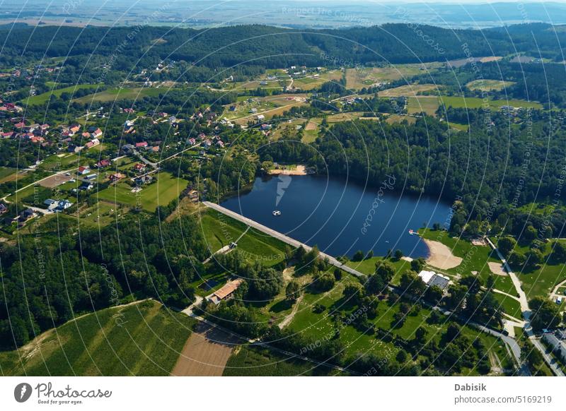 Aerial view of village and lake near mountains at summer day nature landscape aerial panorama countryside suburb rural area pond resting zone poland sobotka