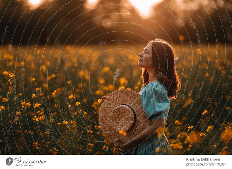 Happy woman in blooming canola flowers field. Lady in retro dress, spring season agricultural background beautiful beauty blonde blossom bright canola field