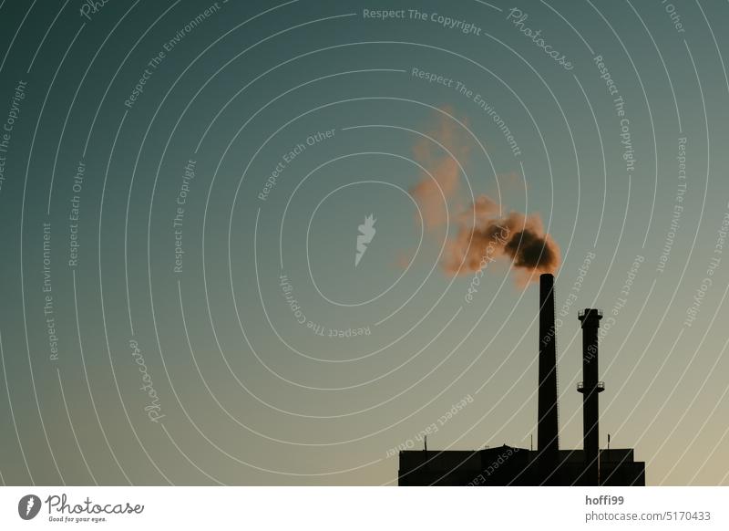Chimney of factory with smoke, steam, emission in front of blue cloudless sky at sunset Emission Smoke Environmental pollution Climate change CO2 emission