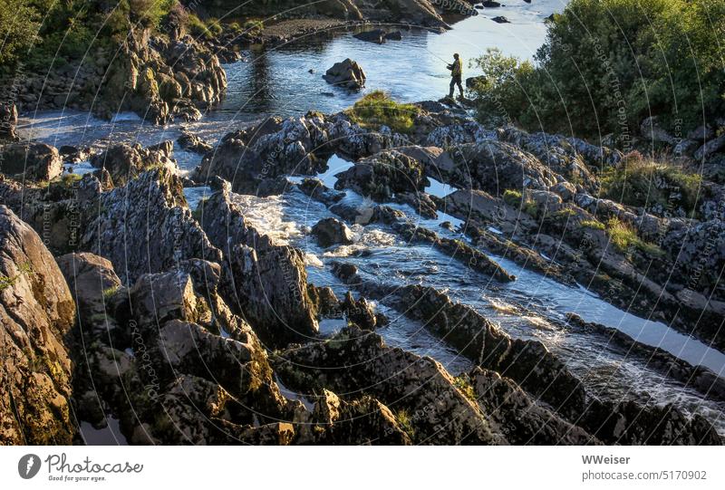 By the wild little river winding through rock formations, an angler stands in the evening light Fishing (Angle) Angler Landscape Rock Flow River structures