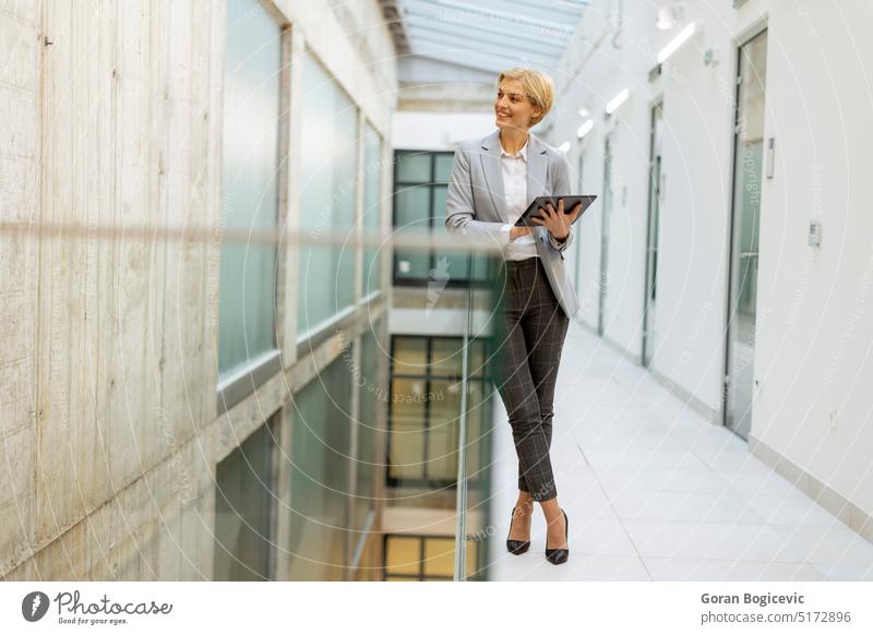 Businesswoman using digital tablet on modern office hallway adult attractive beauty brunette business business person businesspeople businessperson