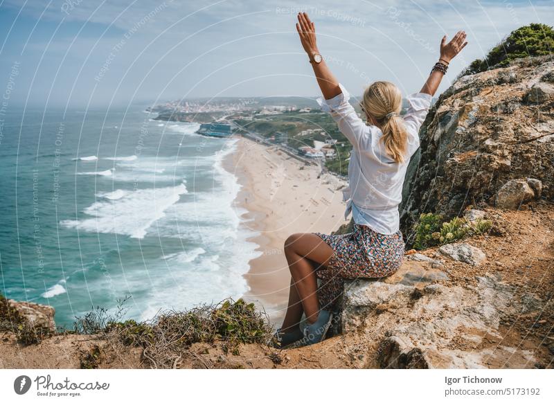 Beautiful women raising hands enjoying atlantic ocean coast on Praia da Adraga, Sintra, Portugal. Atlantic Ocean coastline landscape travel vacation portugal
